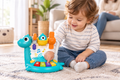 Bebé jugando con el piano-dinosaurio y ondas musicales