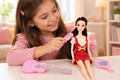 Niña jugando con la muñeca, guitarra y accesorios