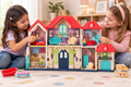 Niñas jugando con la villa de muñecas